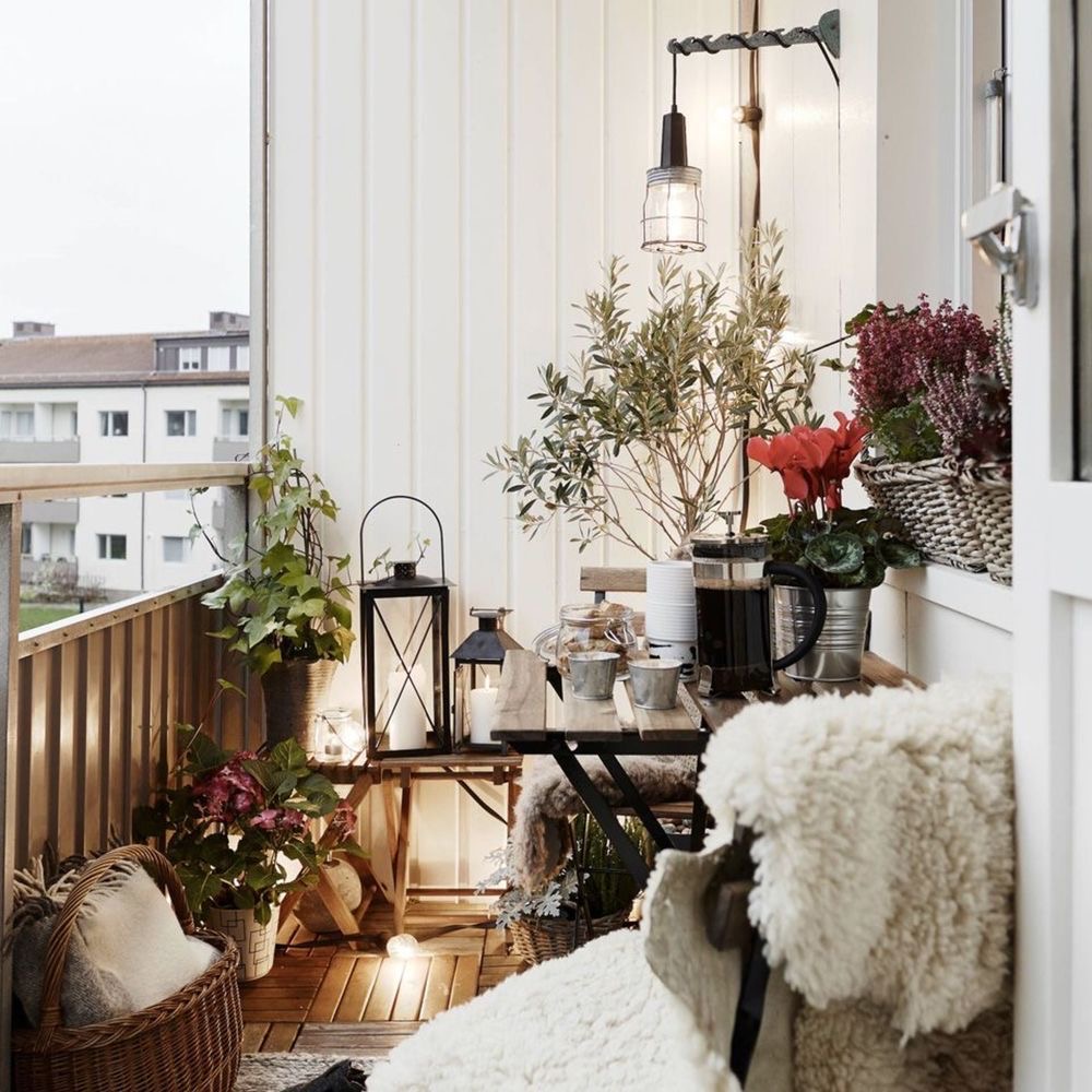 photo d'un balcon avec lanternes et plaid pour s'inspirer pour décorer son balcon en hiver