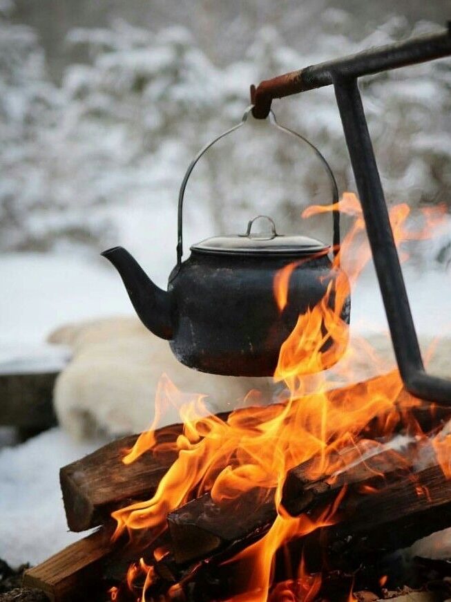 Une bouilloire en fer sur un feu d'extérieur