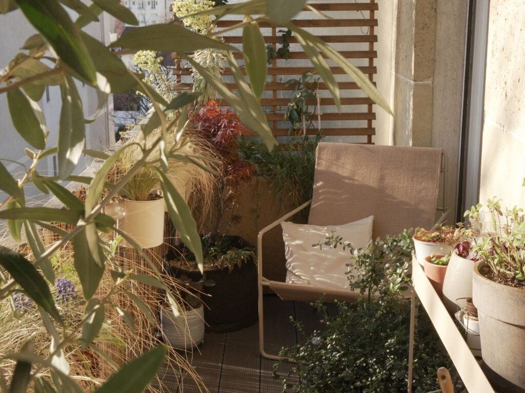 Réalisation de Petites Garrigues à Courbevoie, avec un fauteuil et beaucoup de plantes sur un balcon