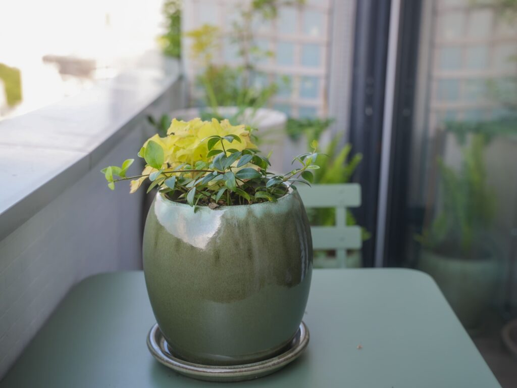 aménagement d'un petit balcon en longueur avec une table et des petits pots verts